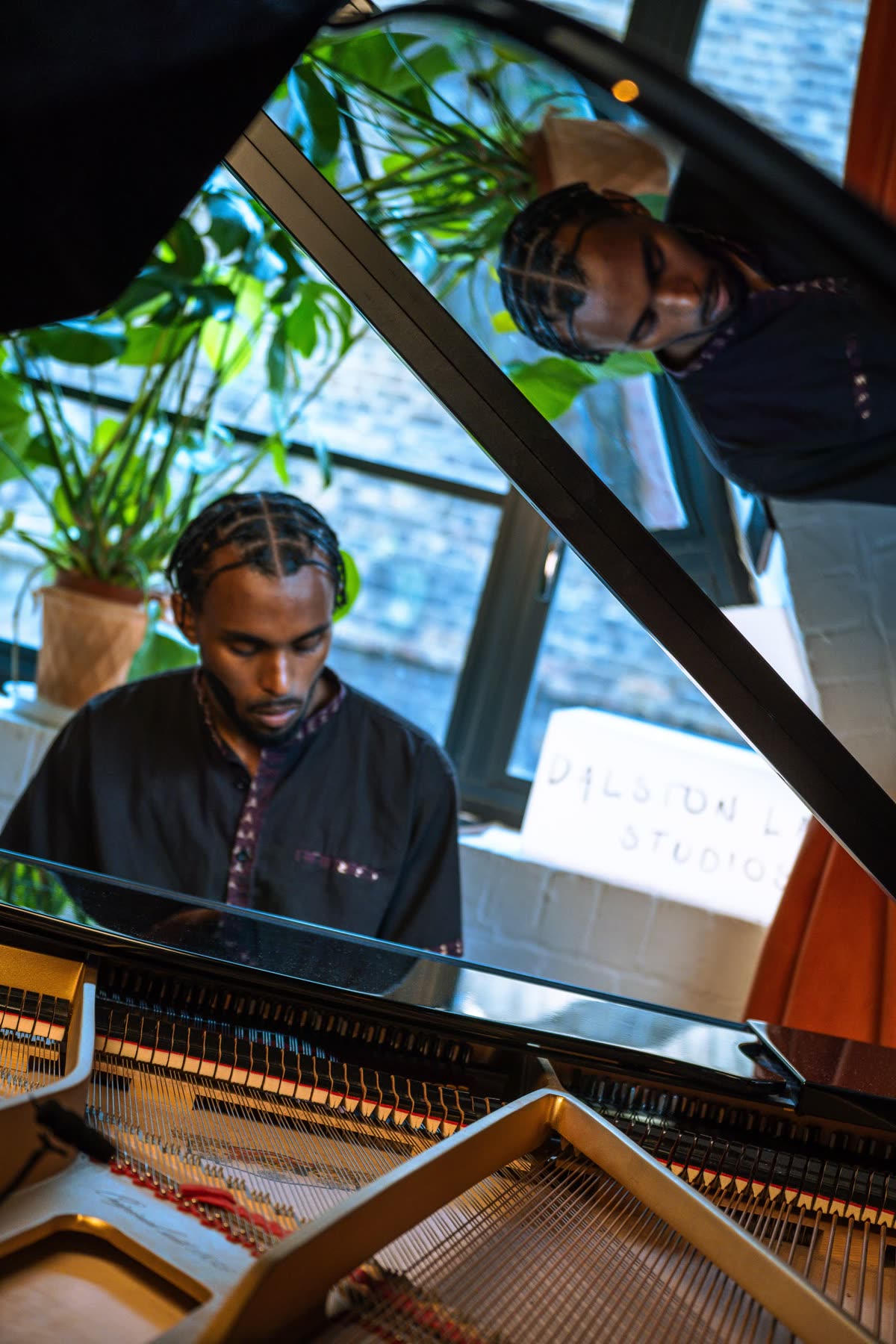 Judah at a grand piano, reflected in its lid